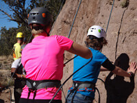 A Staff and student start a climb as part of rock climbing therapy at Discovery Ranch South, a Residential Treatment Center for teenage girls and adolescents assigned female at birth