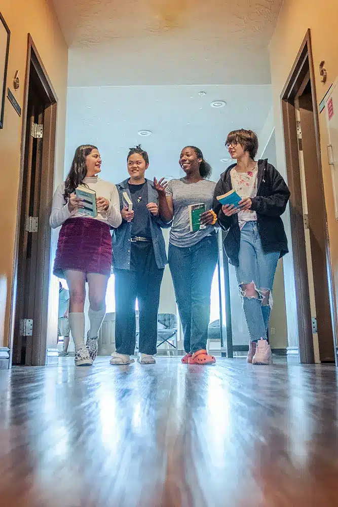 Students walk down the hall during school at Discovery Ranch South, a residential treatment center for youth and adolescents assigned female at birth