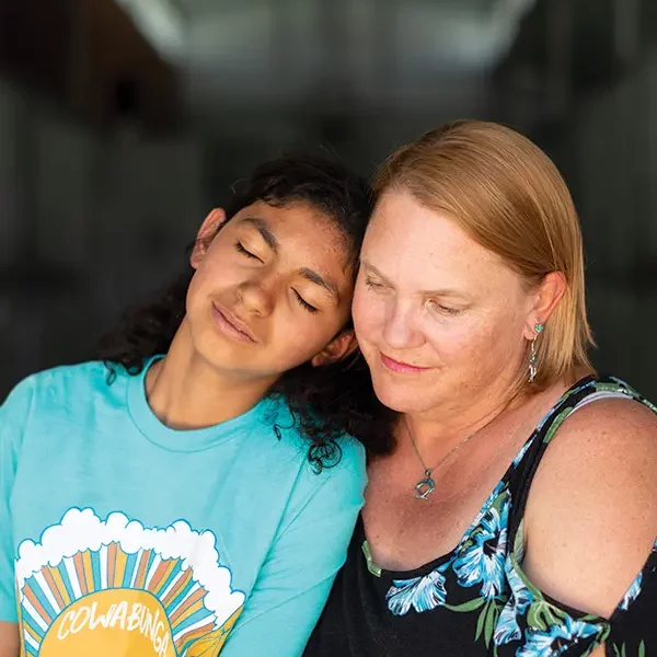 A mother hugs her daughter during a family therapy visit at Discovery Ranch South, a residential treatment center for girls and teens assigned female at birth.
