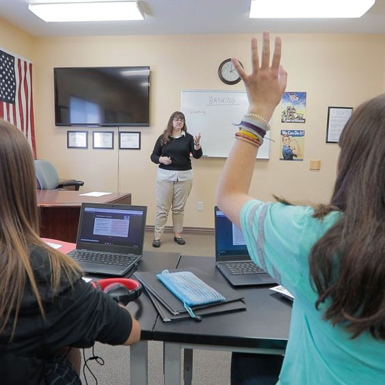 A student raises her hand while attending the therapeutic school at Discovery Ranch South, residential treatment for girls and teens assigned female at birth