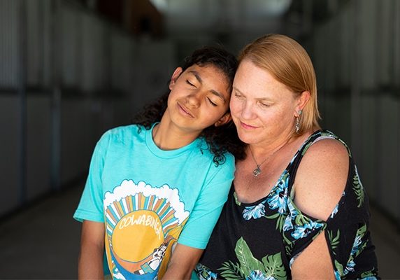 A teenage girl is hugged by her mom while at residential anxiety treatment center | Discovery Ranch South - a residential treatment center for adolescent girls and teens assigned female at birth